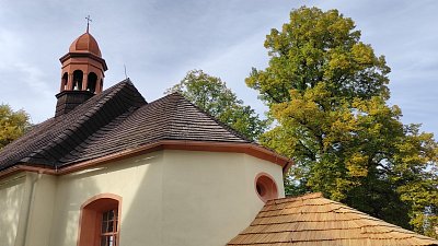 Pětiboký presbytář a pod kulatým okénkem stříška sakristie