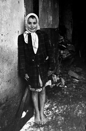 Poválečné Československo, 1946: Devítiletá dívka stojí bosá před poničeným domem v Rožňavě