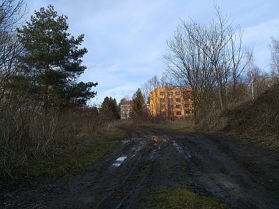 Za posledními paneláky je pouze neudržovaná cesta